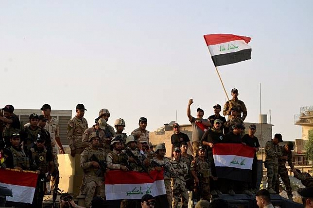 伊拉克特種部隊興高采烈揮舞國旗慶祝收復摩蘇爾。（湯森路透）