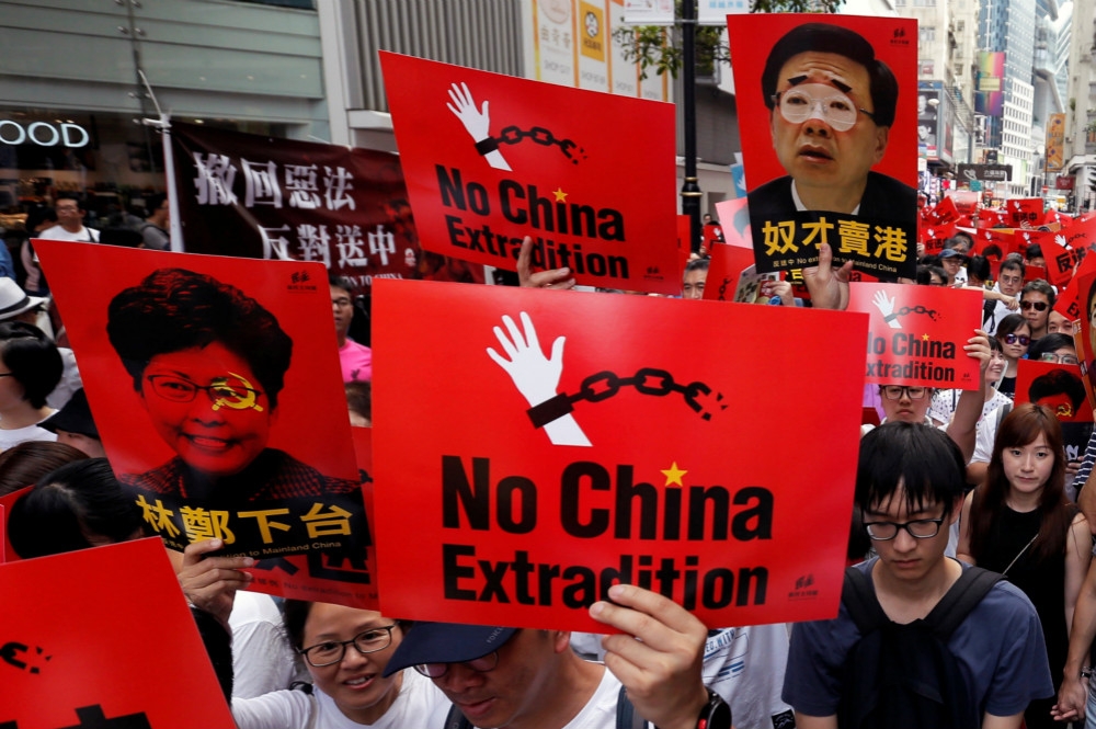 從維園出發、高舉「反送中、撒惡法」標語的大批香港抗議群眾。（湯森路透）