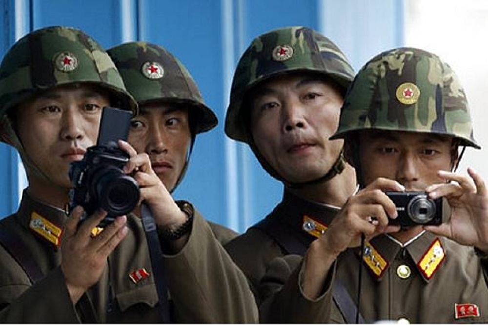 板門店的北韓軍人拿著相機，監視南韓的一舉一動。（美聯社）