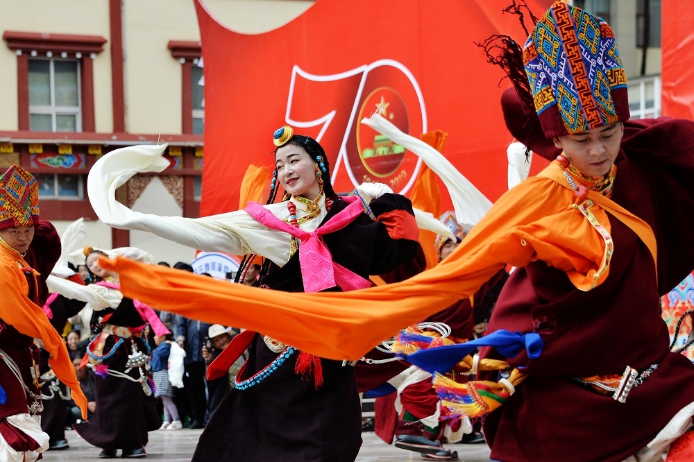 身穿傳統服飾的藏族男女翩翩起舞。（湯森路透）