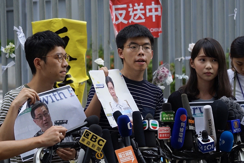 香港眾志秘書長黃之鋒（中）和成員周庭（右）30日早上突然被捕。（攝影：李景濤）