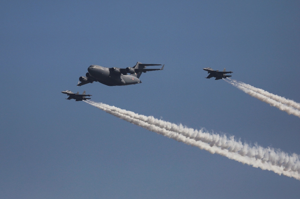 印度空軍現役蘇愷30MKI戰機（左右兩側）與C-17運輸機飛越基地上空。（湯森路透）
