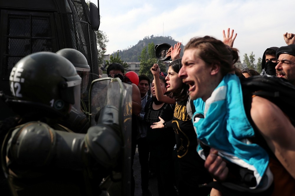 智利抗議者與士兵對峙。（湯森路透）
