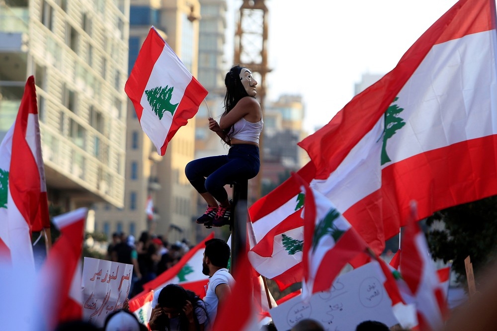 黎巴嫩抗議人士高舉國旗，召開反政府的集會遊行。（湯森路透）