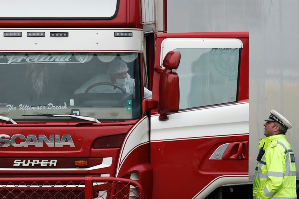英國埃塞克斯郡查獲一輛卡車（中間紅色），載運裝載39具屍體的貨櫃，司機隨機遭警方逮捕。（湯森路透）