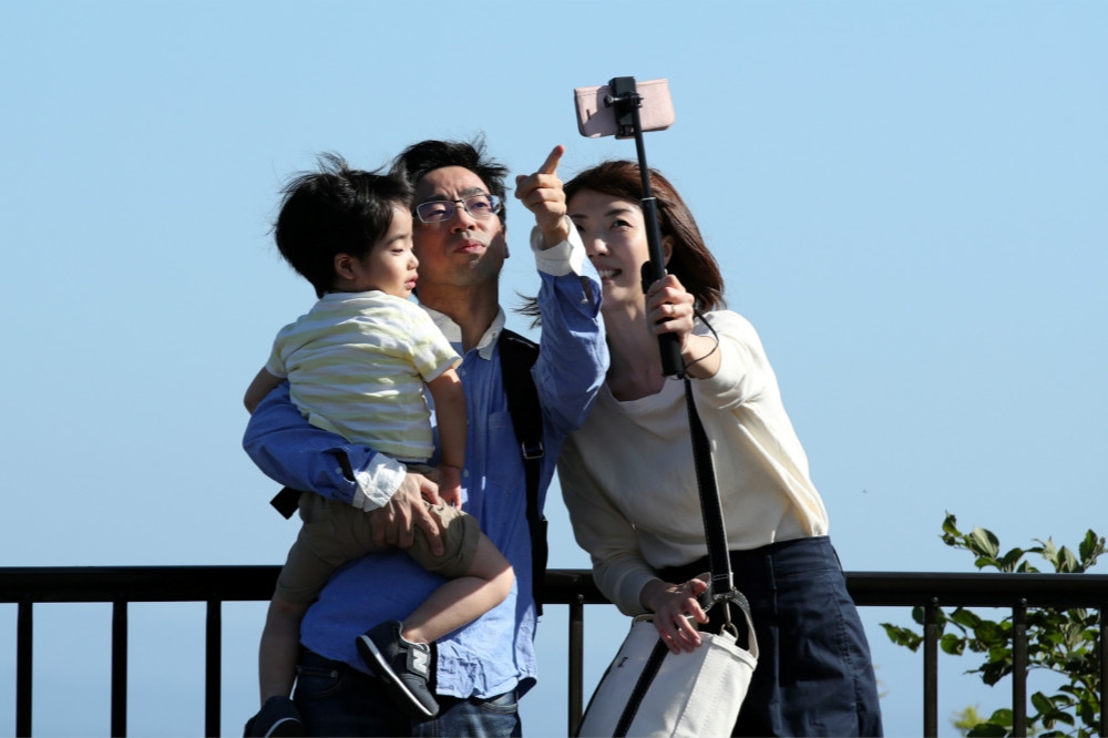 帶著孩子開心自拍的一組日本家庭。（湯森路透）