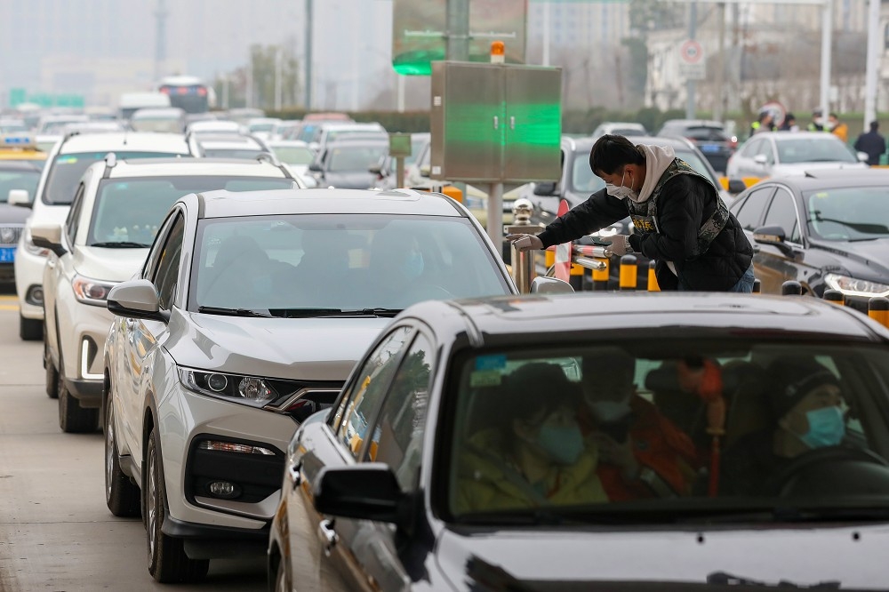 中國湖北省武漢市23日宣布封城，離境車輛大排長龍。（湯森路透）