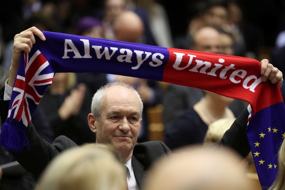 歐洲議會議員高舉「永遠團結」的圍巾。（湯森路透）