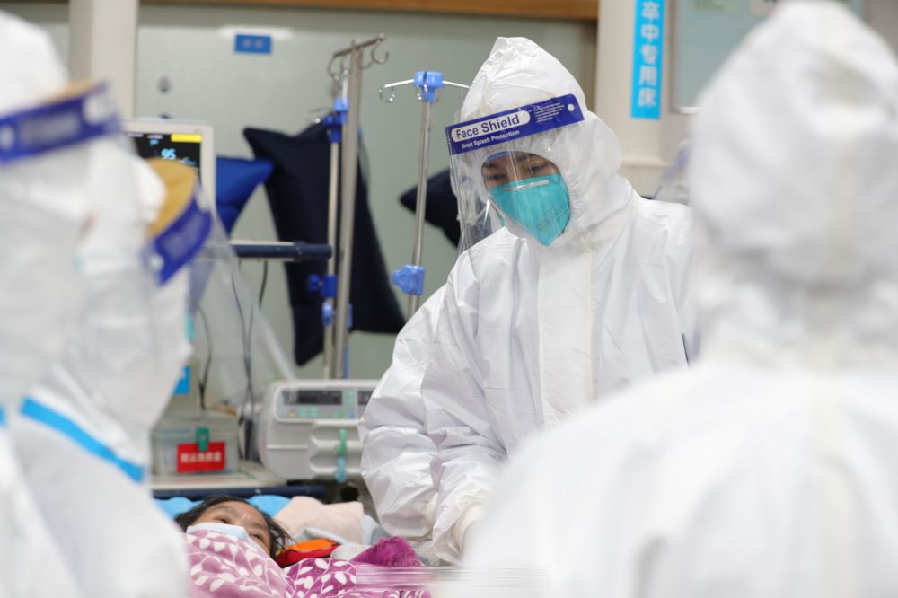 武漢的醫療人員身穿防護衣照顧病患。（湯森路透）