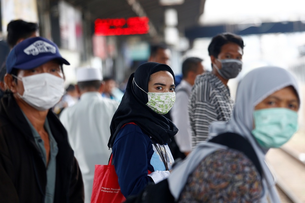 印尼雅加達一處車站乘客紛紛戴上口罩。（湯森路透）