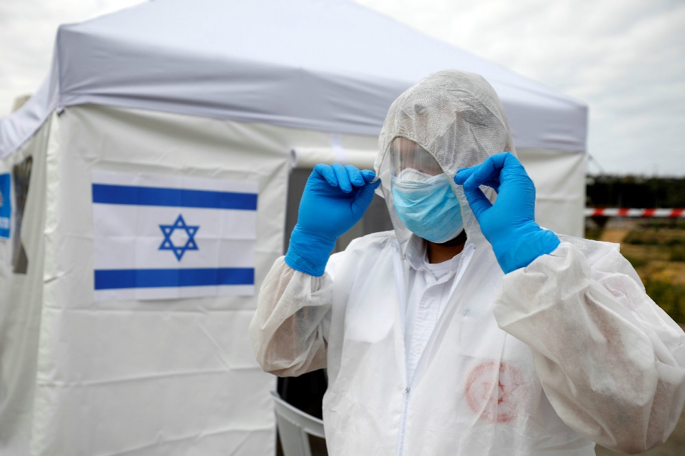 以色列防疫人員穿戴全套裝備。（湯森路透）