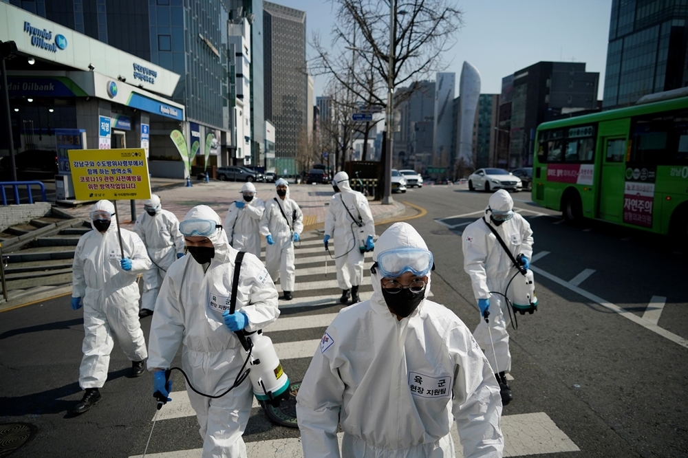 穿著防護服的韓國軍人在首爾購物區進行消毒（湯森路透）