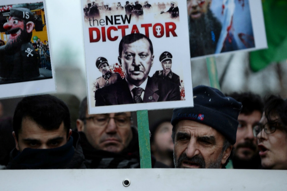 比利時示威群眾高舉諷刺埃爾多安的海報，抗議他對難民的政策。（湯森路透）