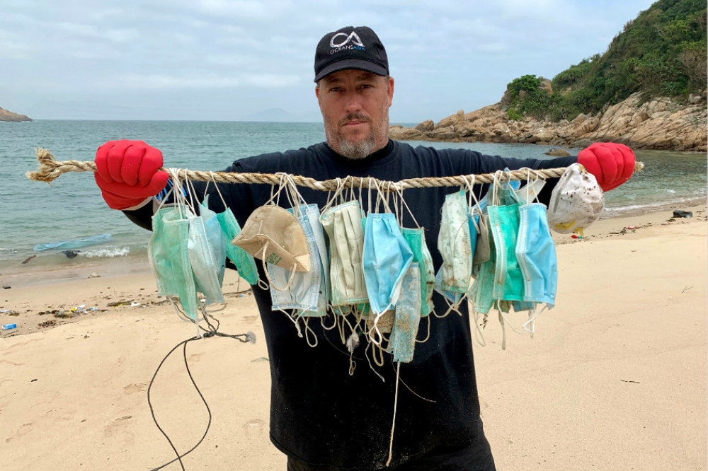 環保團體在香港離島沙灘上，尋獲大量亂丟的用後口罩垃圾。（湯森路透）