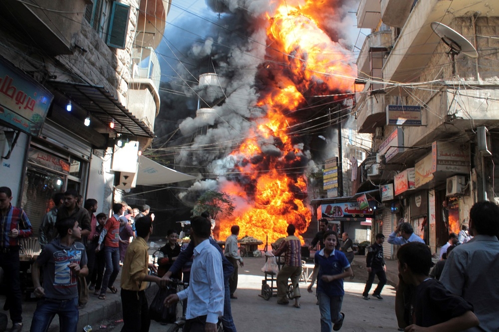 2013年的敘利亞阿勒坡（Aleppo）油行起火，民眾紛紛逃離。（湯森路透）
