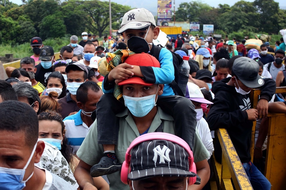 委內瑞拉人民戴著口罩在哥倫比亞邊界等待通行。（湯森路透）