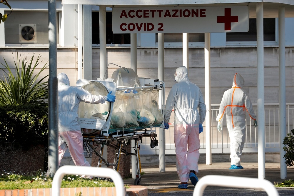 義大利羅馬一處醫院，醫護人員協助運送武漢肺炎患者。（湯森路透）