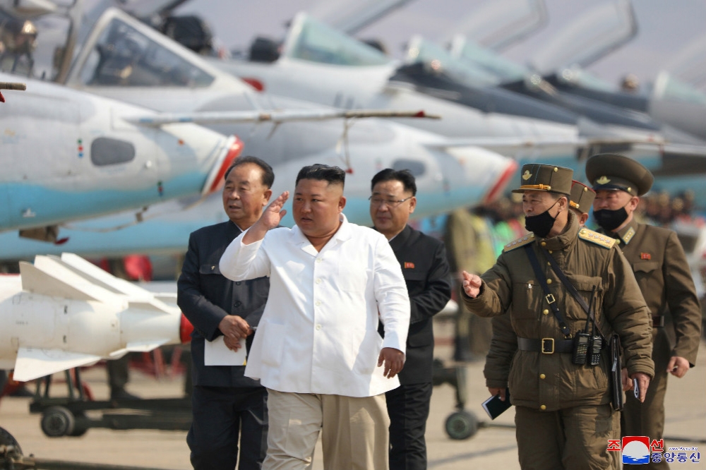 金正恩（正中間）親自前往基地視察北韓空軍飛行員。（湯森路透）