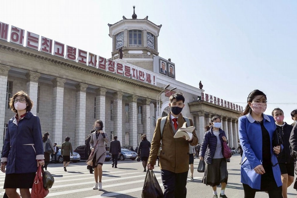 北韓平壤車站前戴口罩的群眾。（湯森路透）