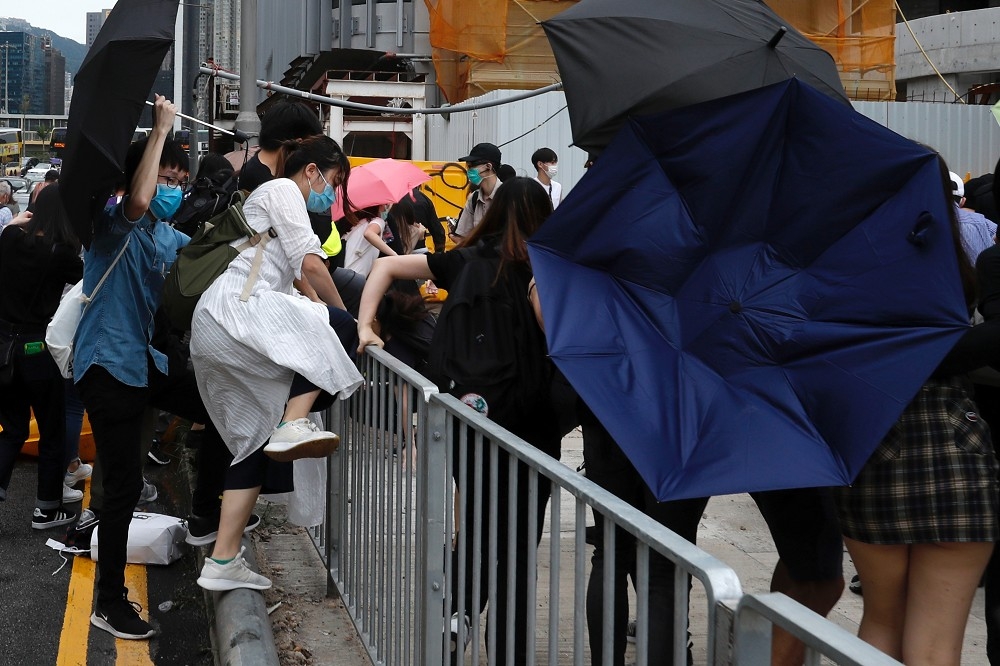 香港抗議民眾手持雨傘保護自己。（湯森路透）