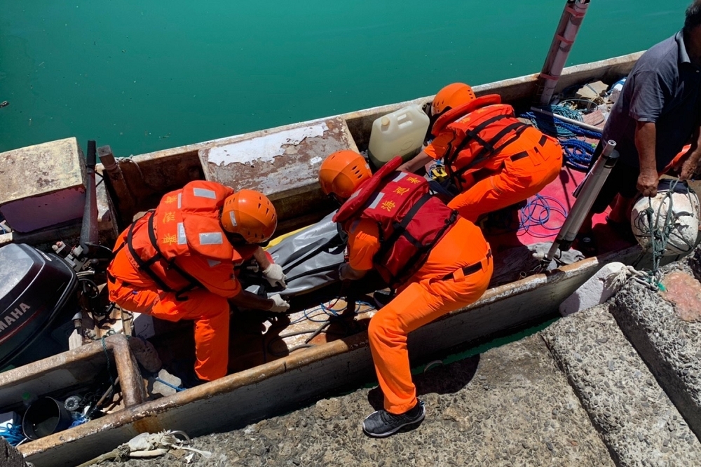海巡人員獲報後，由救難人員潛入水中尋獲一具男性屍體，並將其打撈上岸。（取自海巡署網站）