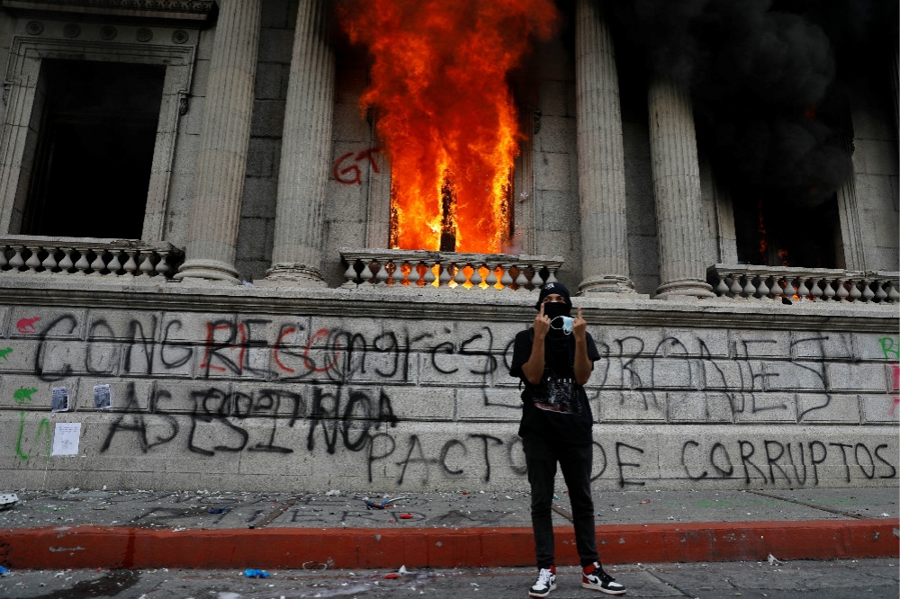 示威者在被縱火的瓜地馬拉國會大樓外。（湯森路透）