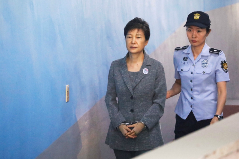 由女警押送、上手銬前往法庭的南韓前總統朴槿惠（左）。（湯森路透）