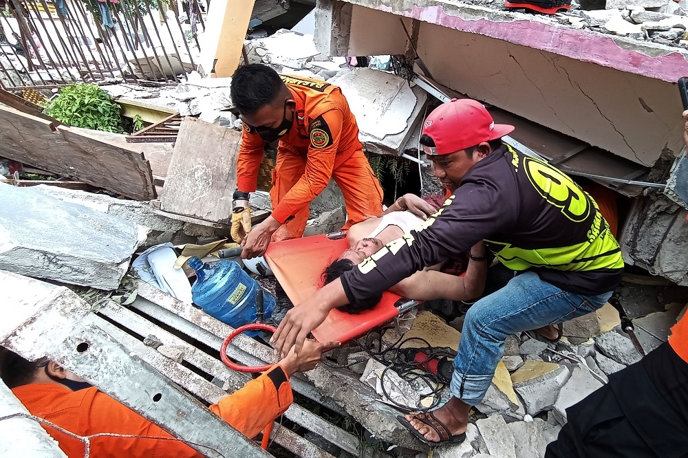 搜救人員在馬穆朱縣倒塌的醫院殘骸中，全力搶救受困民眾。（湯森路透）