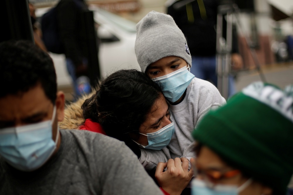 委內瑞拉的移民在尋求美國的庇護以後，與兒子在美墨邊界擁抱哭泣。（湯森路透）