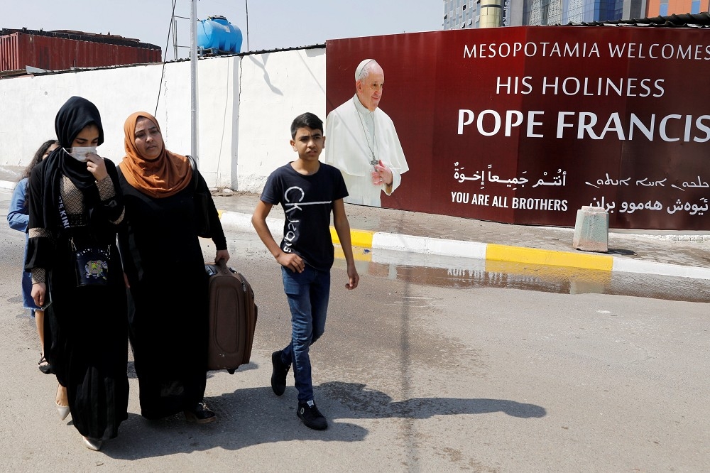 伊拉克居民通過教宗造訪的海報。（湯森路透）