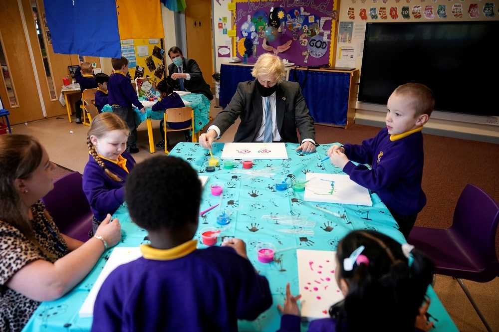 3月1日英國首相強生視察疫情後開放的當地小學。 （湯森路透）
