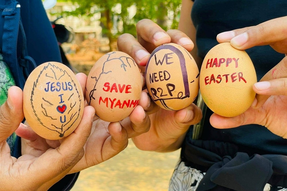 緬甸抗議者手持繪製的彩蛋表達訴求。（湯森路透）