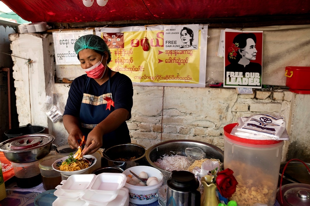 緬甸仰光一名婦女正在供餐給抗議群眾。（湯森路透）