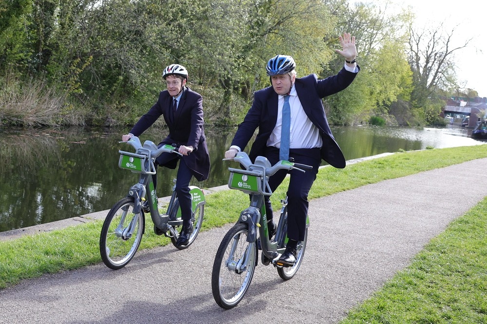英國首相強森搭直升機參加推廣腳踏車選舉行程。（史崔特推特）