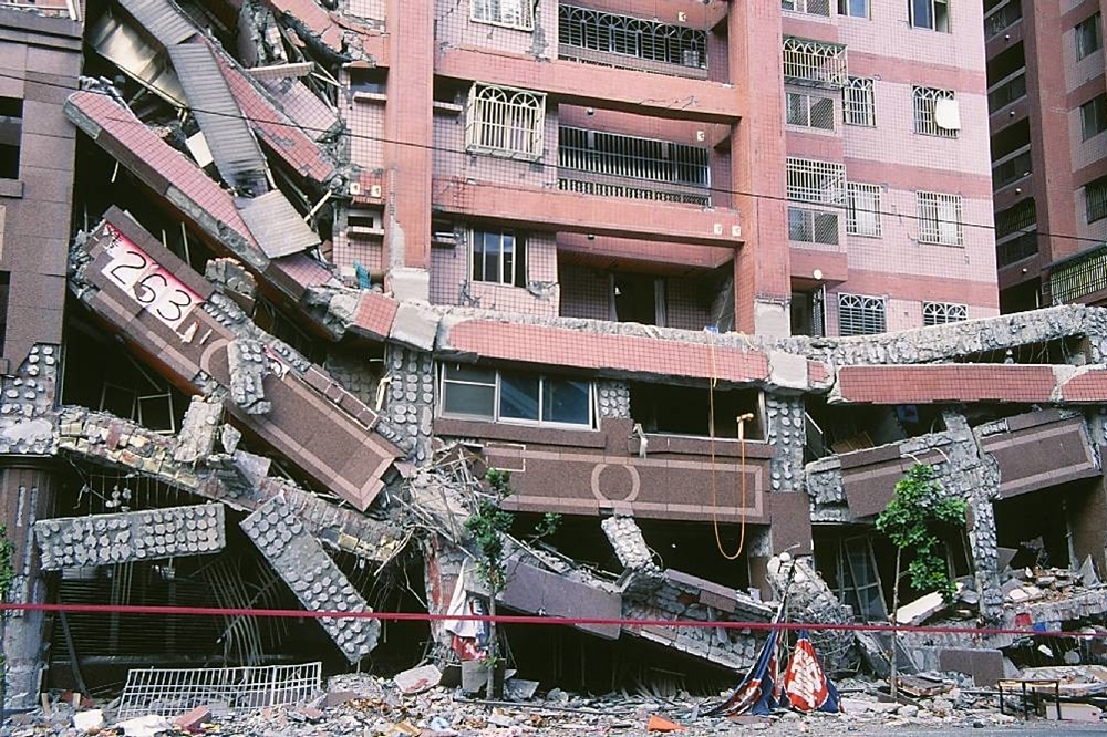 在921大地震中全倒的台中「德昌新世界」大樓（2014 © 鵬智 Bird 賴 Lai , 921台中德昌新世界-賴鵬智 @ Flickr, CC BY-SA 2.0.）