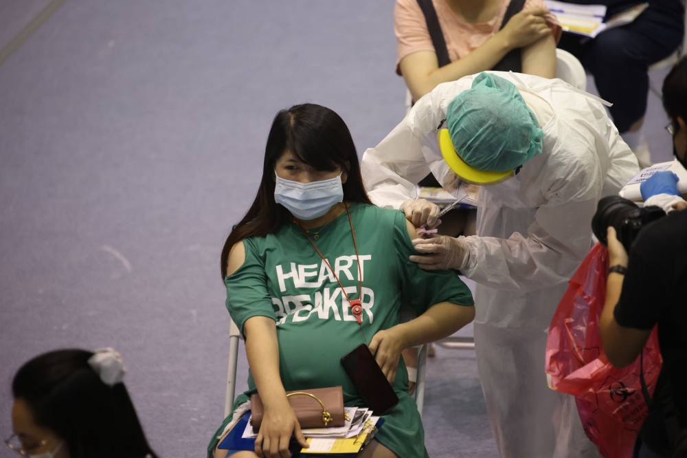 圖為22日新竹市體育館內孕婦施打疫苗。（陳愷巨攝）