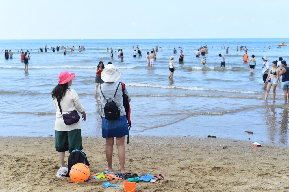 行政院23日宣布27日起降至二級警戒，國家公園部分也頒布防疫措施包括到沙灘也要戴口罩。（資料照片／李昆翰攝）
