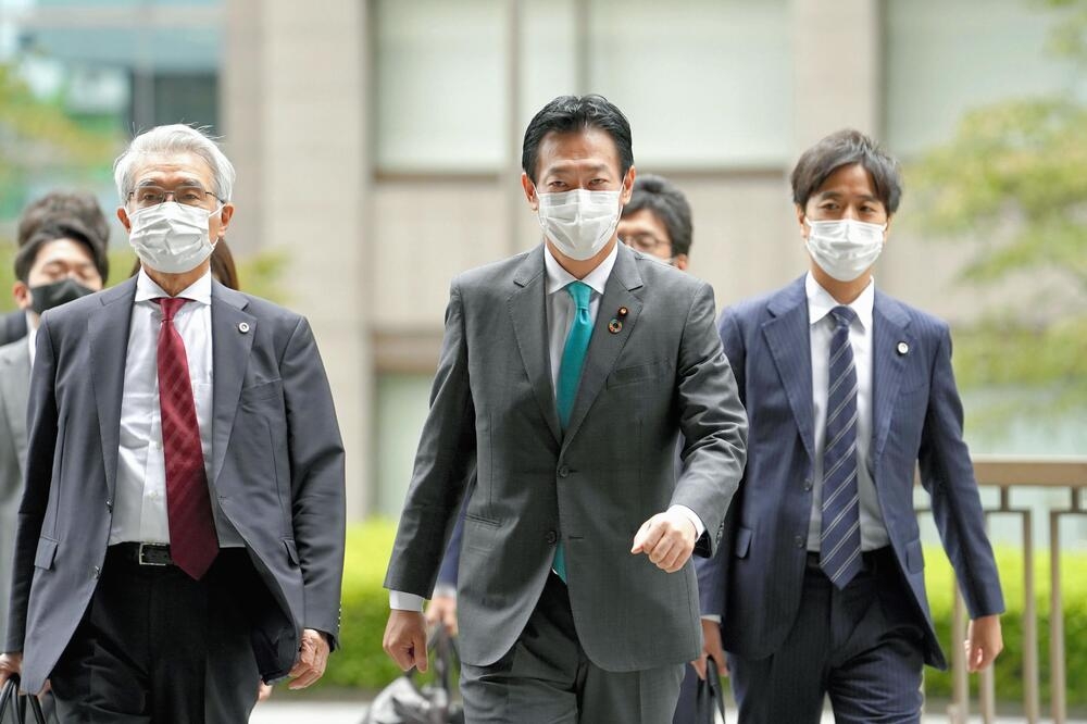 日本無黨籍眾議員秋元司（中央）在律師陪同下出庭應訊。（湯森路透）
