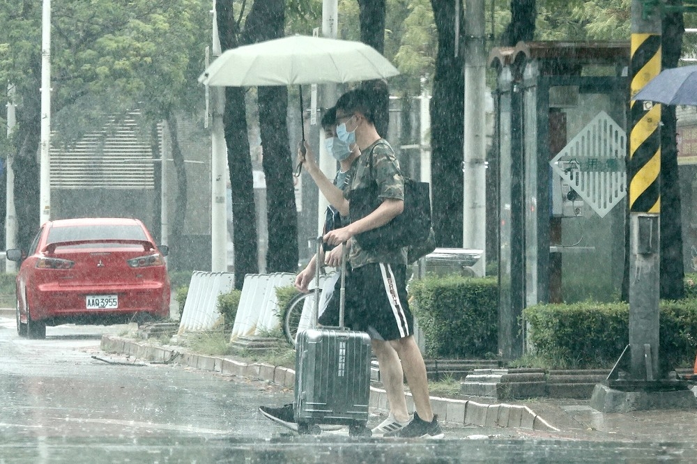 中央氣象局18日下午針對5縣市發布豪大雨特報，提醒民眾外出須注意大雨。（資料照片／王侑聖攝）