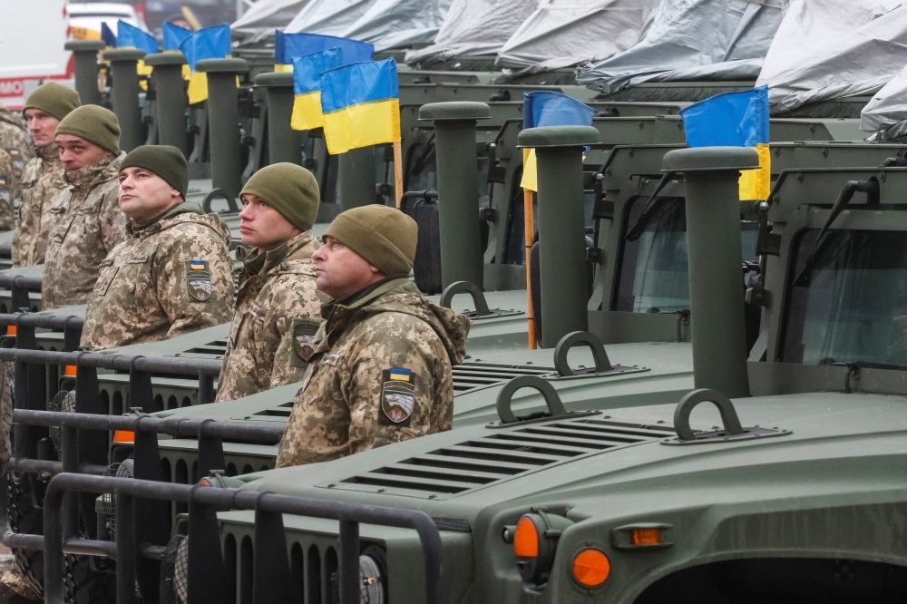 烏克蘭軍人站在裝甲車前。（湯森路透）