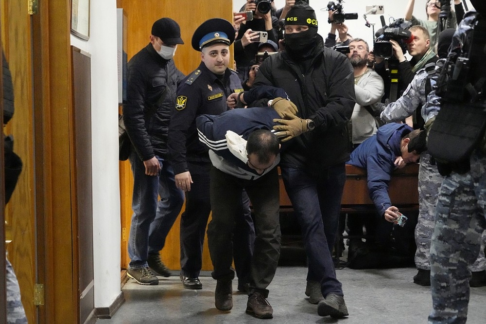 莫斯科音樂廳槍擊案事件後，槍手在逃亡過程中遭逮捕之一。圖為俄國FSB官員與警方押送其中一名嫌疑犯。（美聯社）