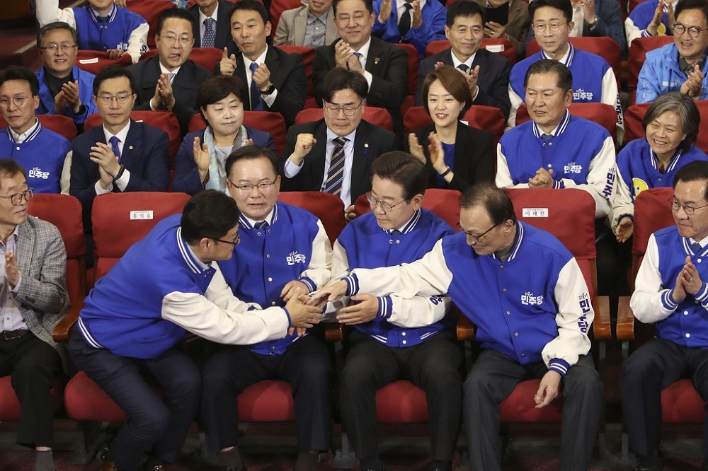 南韓最大在野黨共同民主黨黨魁李在明（右3）10日晚間和候選人一起觀看開票轉播，相互加油打氣。（美聯社）