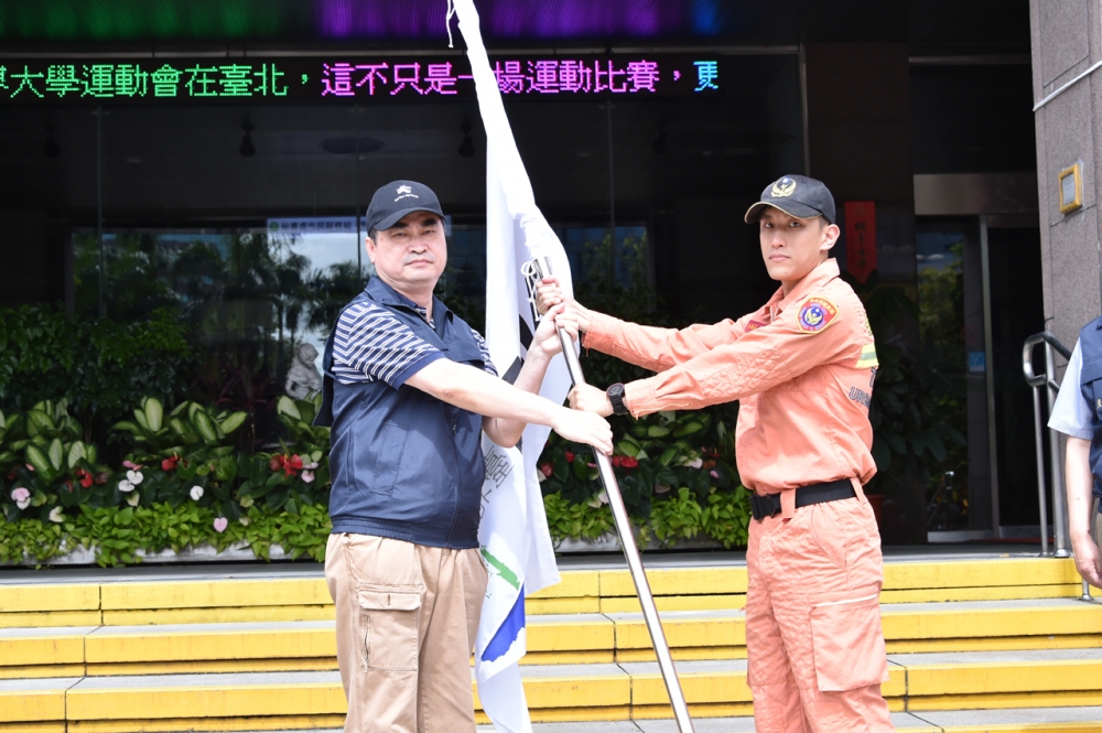 台北市政府緊急災防支援小組10日上午集結，由副市長鄧家基（左）授旗後消防局副中隊長黃騰頡（右）帶隊出發台東救災。（北市府提供）