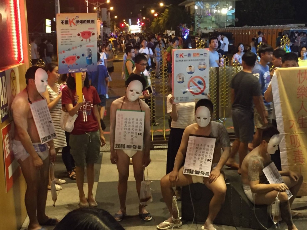一群毒癮者裸身掛上標語牌，以自身經歷勸導民眾勿吸毒。 （翻攝自花蓮同鄉會臉書）