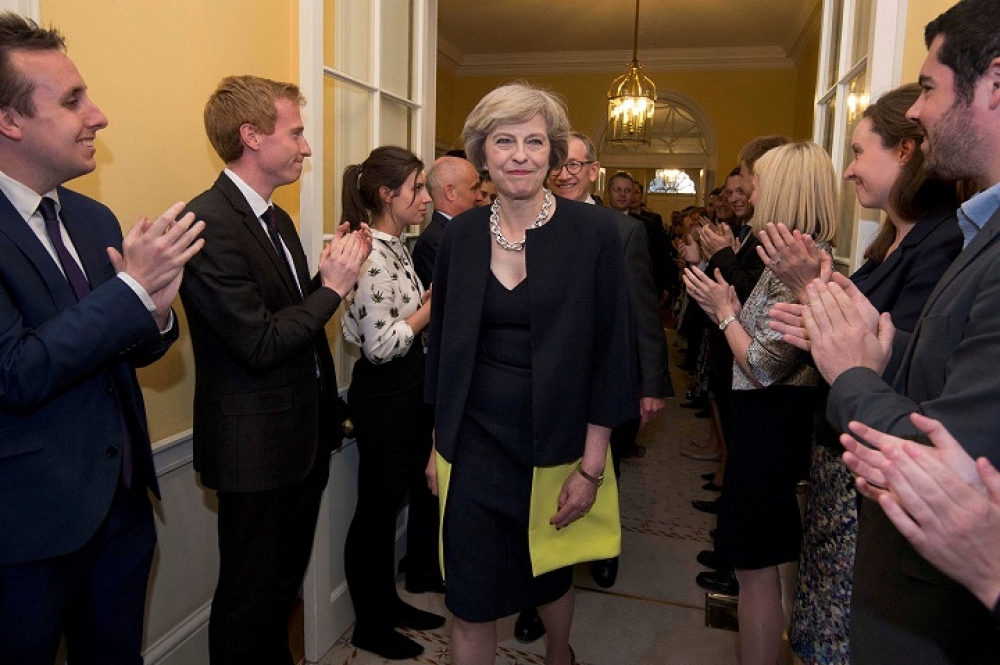 英國首相梅伊及先生菲利浦步入首相官邸內。（湯森路透）