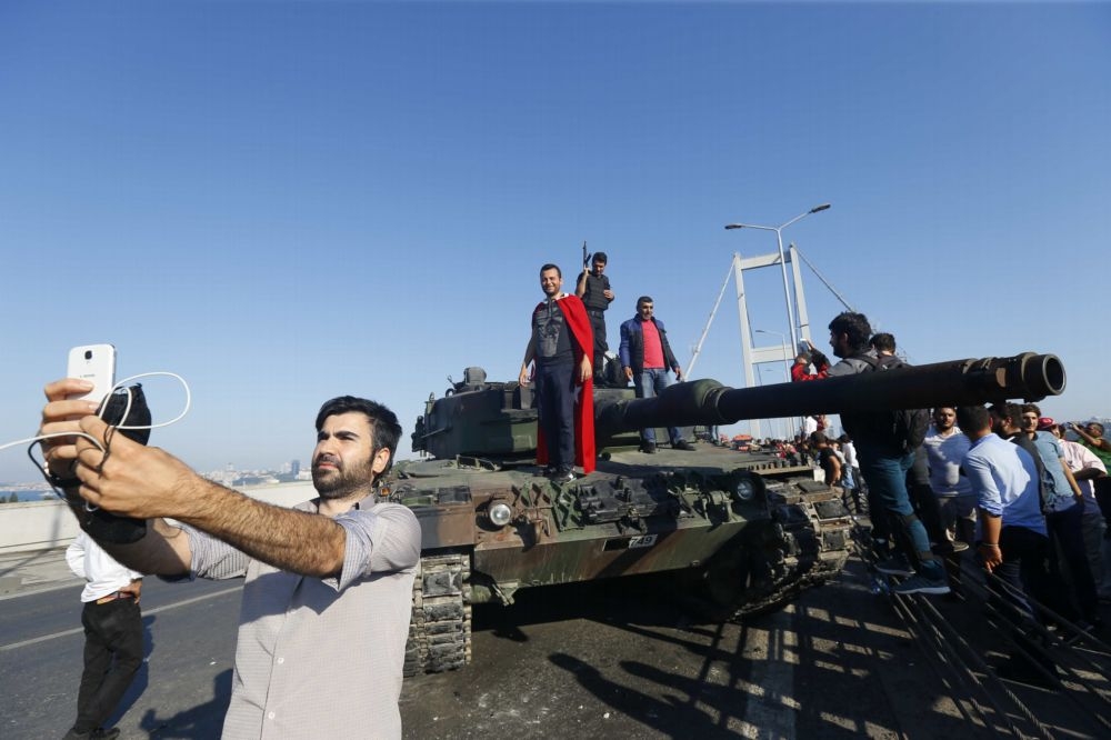 土耳其當地時間15日晚間9時45分驚傳政變，落幕後1名男子和坦克合影留念。 （湯森路透）