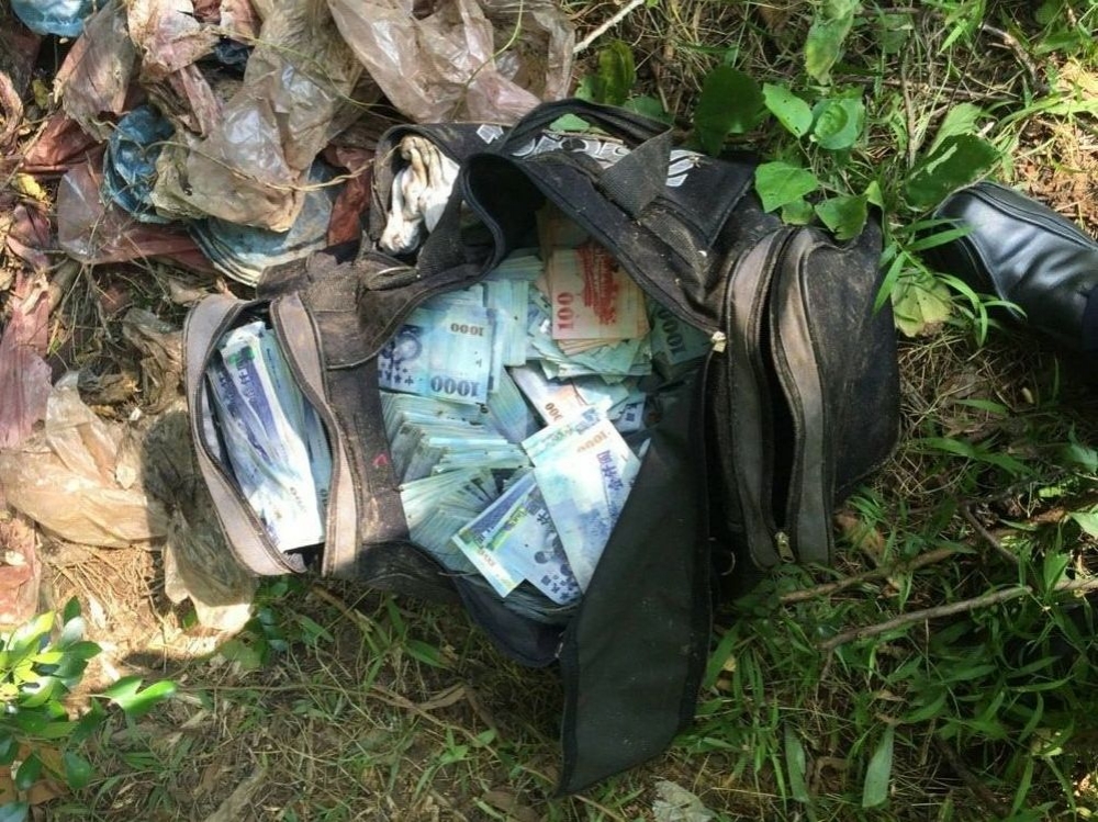 西湖公園垃圾堆尋獲主嫌安德魯的黑色提袋，內有大量現金，警方正在清點中。（警方提供）