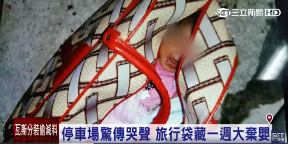 一名約兩周大女嬰包裹白色毛巾、裝在米紅色手提旅行袋內，遭遺棄在停車場。（翻攝自三立新聞）