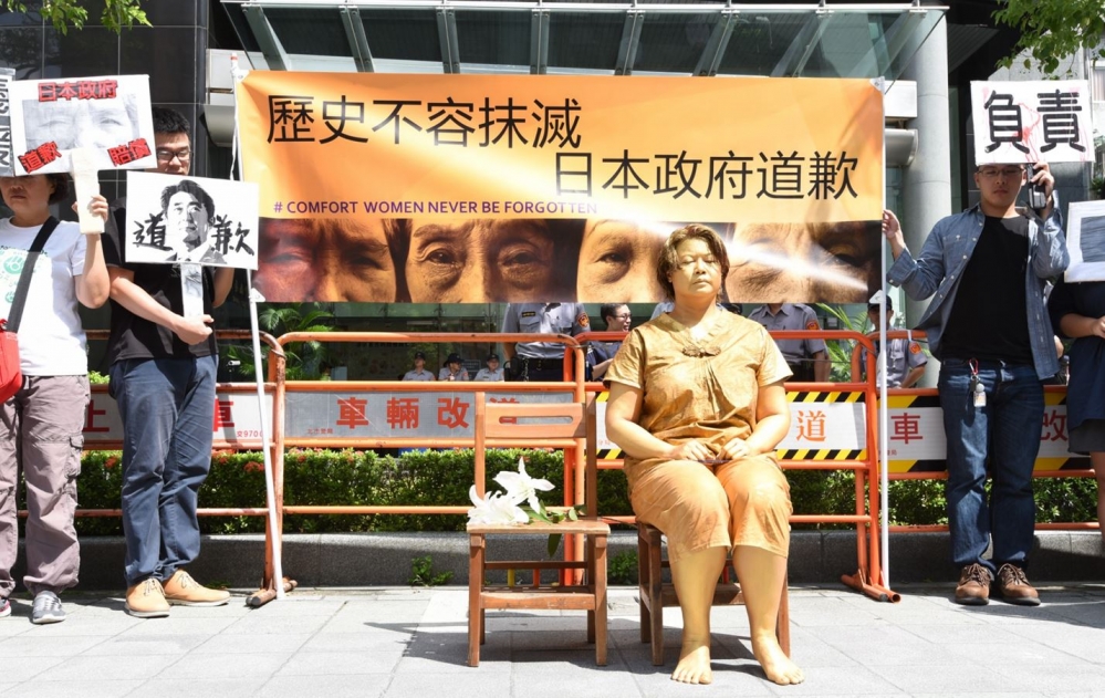 婦女救援基金會15日再度前往日本交流協會前，邀請街頭藝術家扮演慰安婦在現場靜坐，籲日本政府正式道歉。（攝影：葉信菉）
