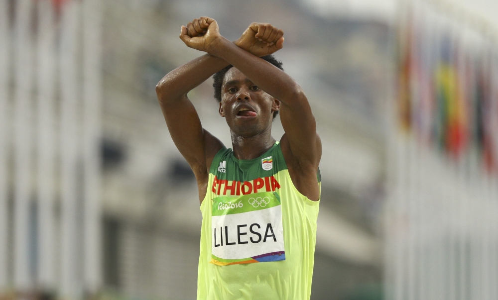 衣索比亞田徑選手利勒沙在通過終點線時，高舉雙手在頭部上方做出交叉動作，聲援國內示威同胞。（湯森路透） 